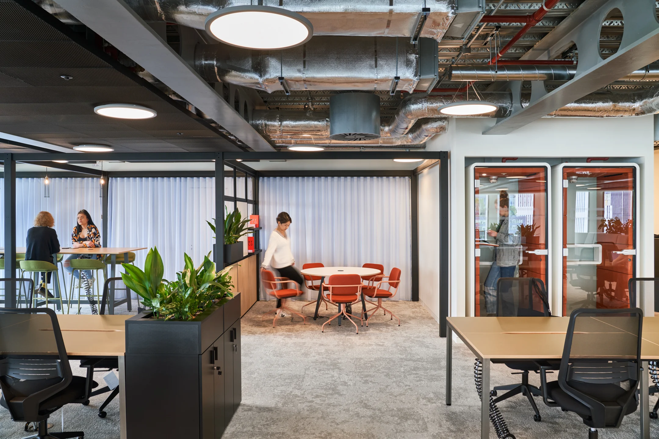 Group of office workers walking down an indoor corridor together during a midday break